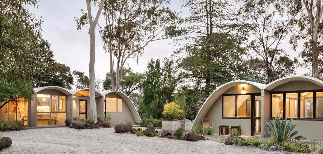 Curved concrete forms of Rice House set among trees